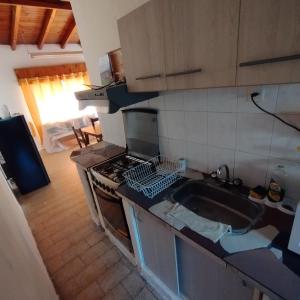 a kitchen with a sink and a stove top oven at Alquiler por Día SyA Cipolletti in Cipolletti