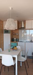 a kitchen with a white table and white chairs at Bungalow da Romy in Vila Praia de Âncora