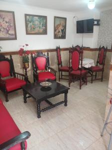 a room with chairs and a table and a tv at Casa estilo colonial próximo Paço Municipal in Goiânia