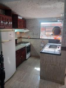 a kitchen with a white refrigerator and a stove at Casa estilo colonial próximo Paço Municipal in Goiânia