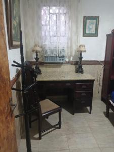 a desk with a chair in a room with a window at Casa estilo colonial próximo Paço Municipal in Goiânia +12 photos