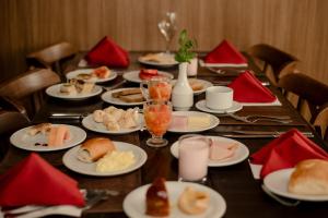 a long table with plates of food on it at Locanda Hotel in Novo Hamburgo