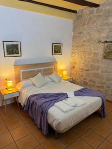 a bedroom with a large bed with two tables and two lamps at Fonda la Plaza in Valderrobres
