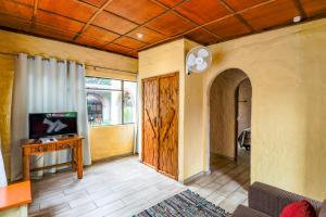 a living room with a couch and a tv and a door at Flamboyant Guesthouse in Bela-Bela