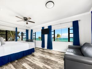 a bedroom with blue curtains and a bed and a couch at Neptune Oceanfront Rentals in Hollywood