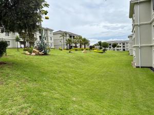 a yard with green grass and houses at The Calm Corner in Trevallyn