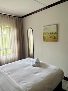 a white bed in a bedroom with a picture on the wall at The Calm Corner in Trevallyn +38 photos