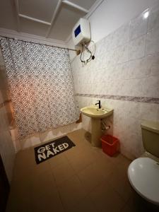 a bathroom with a toilet and a sink at Kath's Hub in Lagos +8 photos