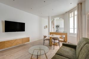 a living room with a couch and a table at Saint mandé Place du marché in Saint-Mandé