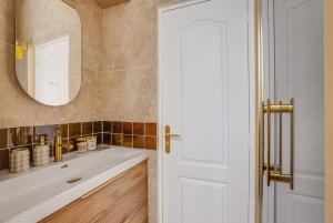 a bathroom with a white sink and a mirror at Saint mandé Place du marché in Saint-Mandé +4 photos