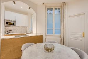 a kitchen with a table and chairs and a counter at Saint mandé Place du marché in Saint-Mandé