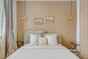 a bedroom with a bed and two lights above it at Saint mandé Place du marché in Saint-Mandé