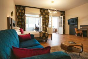a living room with a blue couch and a bed at Residence Black Eagle Lubmin Strand in Lubmin
