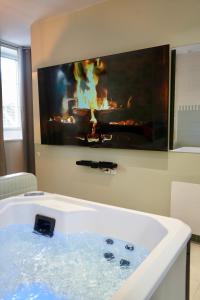 a bathroom with a bath tub with a fireplace at Le Cocon Spa proche Puy DuFou in Mesnard-la-Barotière