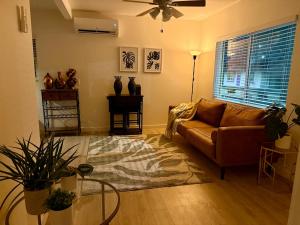 a living room with a brown couch and a fan at Golden Sol Casita in Tempe