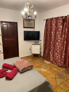 a bedroom with a bed and a tv and a window at Taverna do Paraiso in Janga
