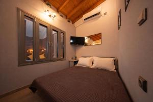 a small bedroom with a bed and a window at Oniro Living - Skra 10 in Mytilene