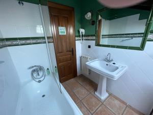 a bathroom with a tub and a sink and a mirror at Posada San Tirso in Toñanes +16 photos