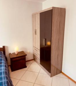 a bedroom with a large wooden cabinet next to a bed at Aconchego - com Garagem in Santa Maria