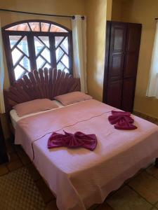 a bedroom with a bed with purple bows on it at Taverna do Paraiso in Janga +22 photos