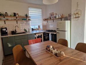 a kitchen with a wooden table and a white refrigerator at Small House on Vrbica in Vrbice +20 photos