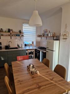 a kitchen with a wooden table and a white refrigerator at Small House on Vrbica in Vrbice