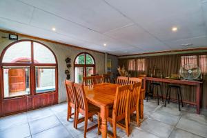 a dining room with a wooden table and chairs at Flamboyant Guesthouse in Bela-Bela