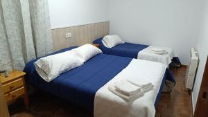 two beds in a hotel room with towels on them at Casas Rurales Villa Vicenta in Alcalá del Júcar +44 photos