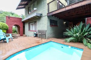 a swimming pool in front of a house at Flamboyant Guesthouse in Bela-Bela