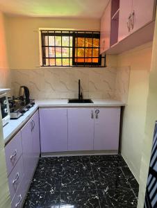 a kitchen with purple cabinets and a sink at Kath's Hub in Lagos
