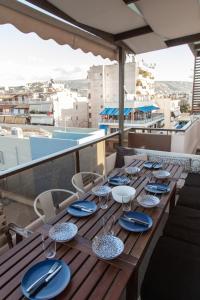 a wooden table with blue plates and chairs on a balcony at "AcroPool" Penthouse with Private Pool & Acropolis View in Athens