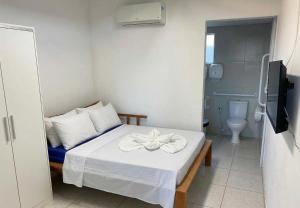 a small room with a bed and a toilet at Pousada Costa Azul in Paulista