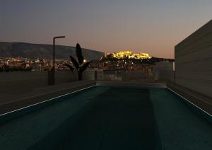 a swimming pool on the roof of a building at night at "AcroPool" Penthouse with Private Pool & Acropolis View in Athens