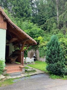 a porch of a house with a picnic table and a tree at Chalupa Špičák in Jablonec nad Nisou