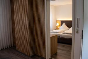 a hotel room with a bed and a bedroom with a door at Apartments-Altenahr in Altenahr