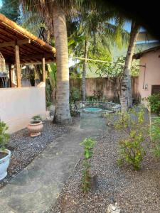 a garden with palm trees and a patio at Taverna do Paraiso in Janga