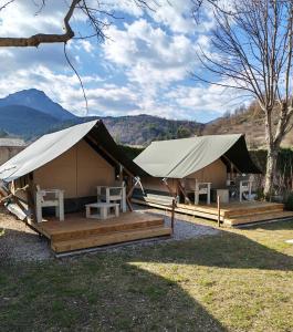 two tents with tables and chairs in a field at Camping les Lavandes, Castellane in Castellane