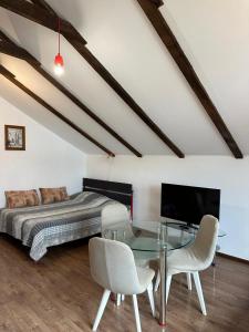 a bedroom with a glass table and a bed at Loft Studio in Igalo