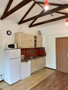 a kitchen with a white refrigerator and wooden cabinets at Loft Studio in Igalo