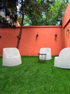 two white chairs and a table in the grass at Kath's Hub in Lagos