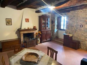 a living room with a table and a fireplace at Finestra sulla Val D'Orcia in Campiglia dʼOrcia +1 photo