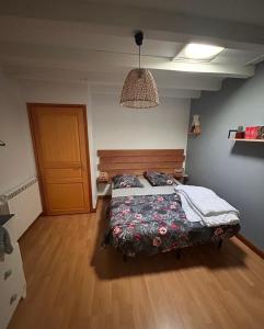 a bedroom with a bed with a wooden headboard at Chambre avec piscine, saison estivale in Urrugne