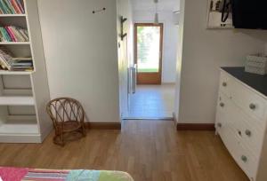 a room with a hallway with a door and a chair at Chambre avec piscine, saison estivale in Urrugne