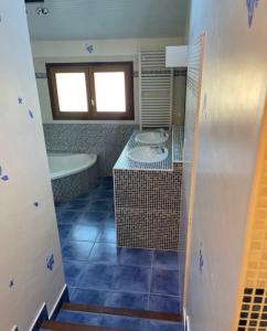 a bathroom with two sinks and a tub and a window at Chambre avec piscine, saison estivale in Urrugne