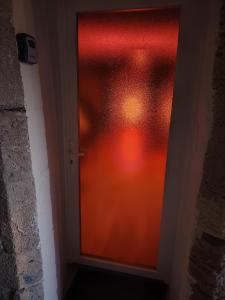 a door with a window with a red curtain at Appartement thème cinéma in Cazouls-lès-Béziers