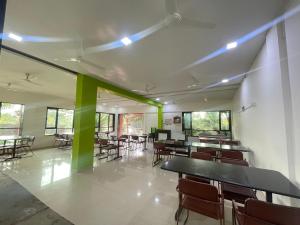 a room with tables and chairs and green columns at Blue Diamond Dapoli in Murūd