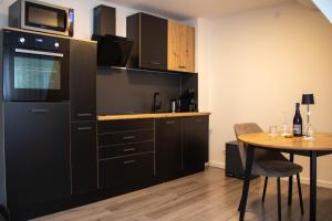 a kitchen with a table and a microwave at Apartments-Altenahr in Altenahr +5 photos