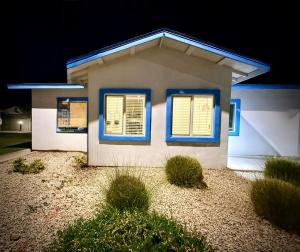 a small white house with blue windows in the night at Azure Casita in Tempe