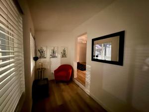 a hallway with a red chair and a mirror at Azure Casita in Tempe