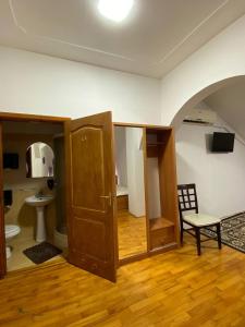 ein Zimmer mit einem Badezimmer mit Toilette und Stuhl in der Unterkunft Готель Даніель in Mukatschewo